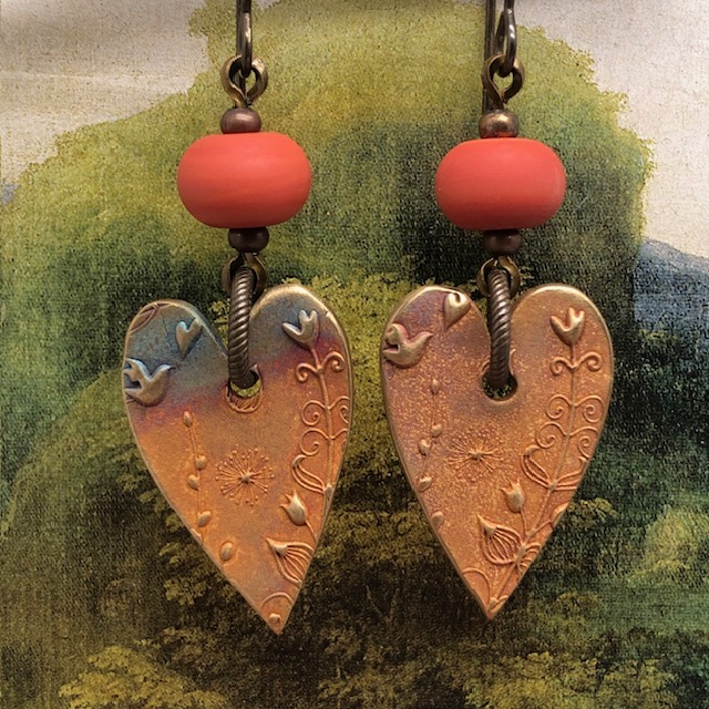 Boucles d'oreilles asymétriques coeurs terracotta composées de pendentifs en bronze et de perles lampwork. Bijoux uniques de créateur.