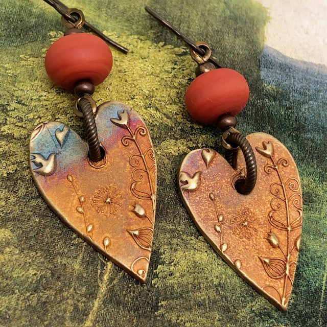 Boucles d'oreilles asymétriques coeurs terracotta composées de pendentifs en bronze et de perles lampwork. Bijoux uniques de créateur.
