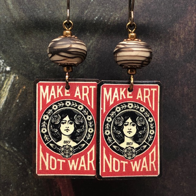Boucles d’oreilles bohème chic composées de pendentifs artisanaux en cuivre illustré représentant l'œuvre d'Obey, Make Art Not War. Bijoux uniques.