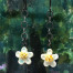 Petites boucles d'oreilles bohèmes composées de pendentifs artisanaux en céramique en forme de fleur et d'une jolie chaîne en argent oxydé. Bijoux uniques.