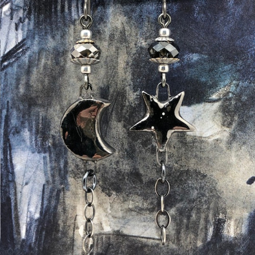 Longues boucles d'oreilles asymétriques Moon and Star composées de pendentifs en céramique platinum. Bijoux uniques de créateur.