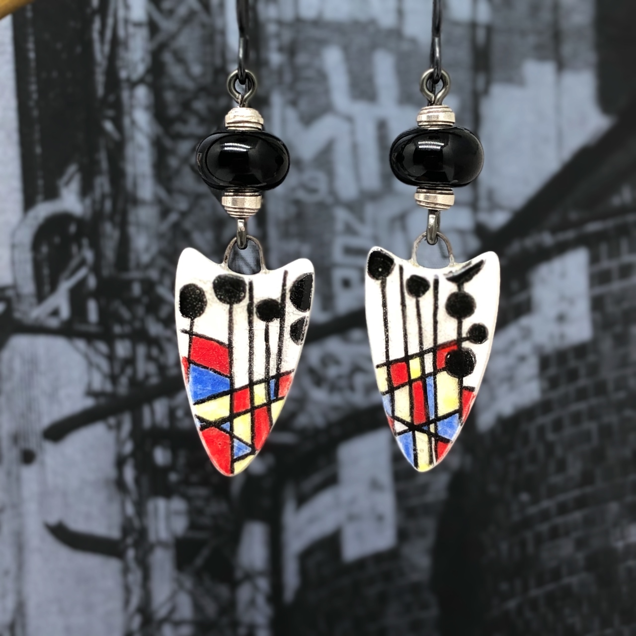 Boucles d'oreilles asymétriques composées de pendentifs en porcelaine avec un motif abstrait multicolore. Bijoux uniques.