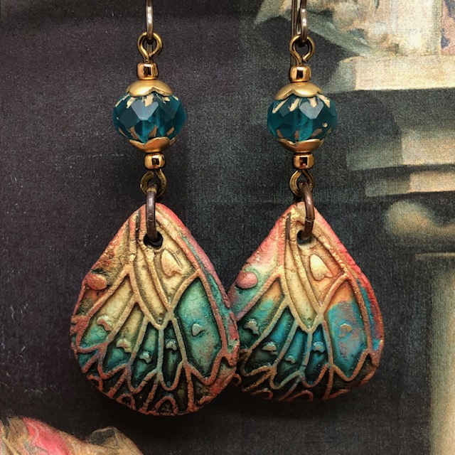 Boucles d'oreilles bohèmes composées de pendentifs en céramique en forme d'ailes de papillon, bleu vert, jaune safran, ocre et bronze. Bijoux uniques.