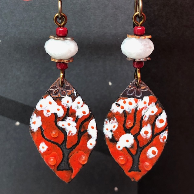 Boucles d'oreilles bohème chic composées de pendentifs en cuivre émaillé qui représentent un arbre à coton sur un fond rouge. Pièces uniques.