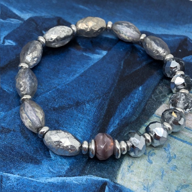 Bracelet élastique bohème chic composé de perles en verre de Bohême ovales, de perles en cristal argentées et transparentes.