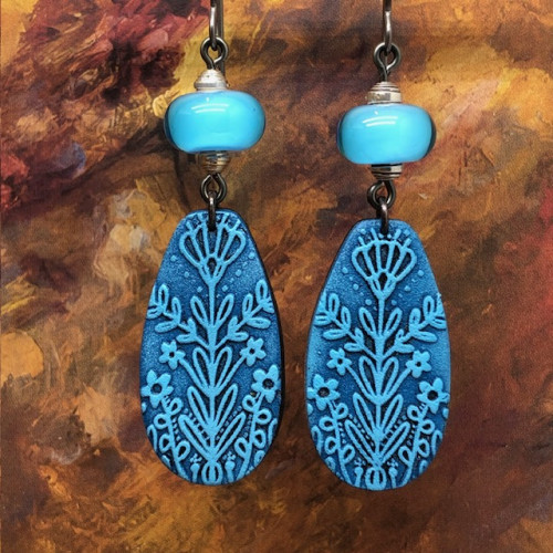 Longues boucles d’oreilles bohèmes composées de pendentifs en argile polymère avec un motif de chardon bleu. Bijoux uniques de créateur.