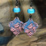 Boucles d’oreilles bohèmes composées de pendentifs en argile polymère avec un motif d'oiseau rose sur un fond bleu indigo. Bijoux uniques de créateur.