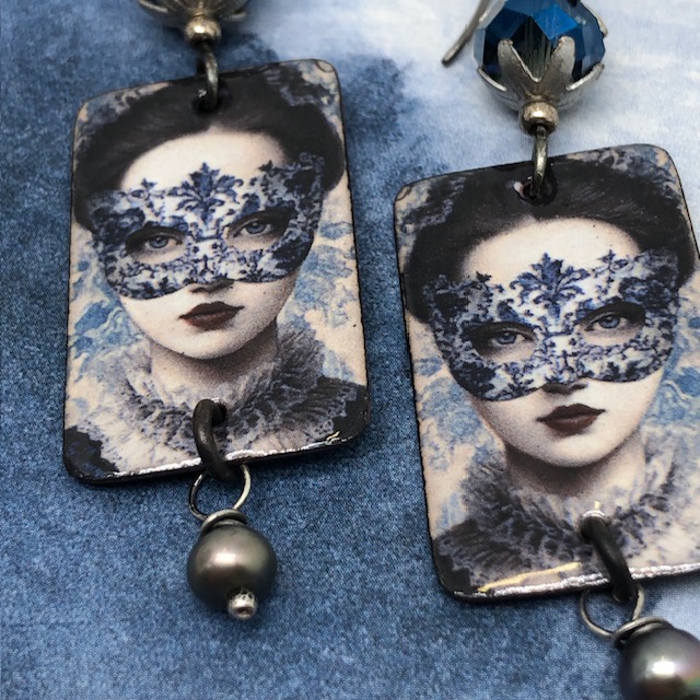 Grandes boucles d’oreilles bal masqué composées de pendentifs en cuivre émaillé bleus avec une femme portant un masque en dentelle. Bijoux uniques.