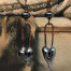 Longues boucles d’oreilles asymétriques composées de pendentifs en céramique et en cuivre en forme de coeur noir diamant. Bijoux uniques de créateur.