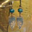 Boucles d'oreilles bohème chic fleurs composées de pendentifs artisanaux en bronze et de perles facettées en apatite vert émeraude.