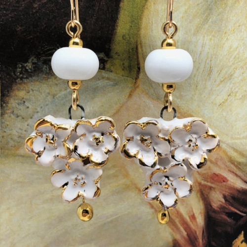Boucles d’oreilles bohèmes composées de pendentifs en céramique qui représentent un bouquet de fleurs blanches et or. Bijoux uniques et poétiques.