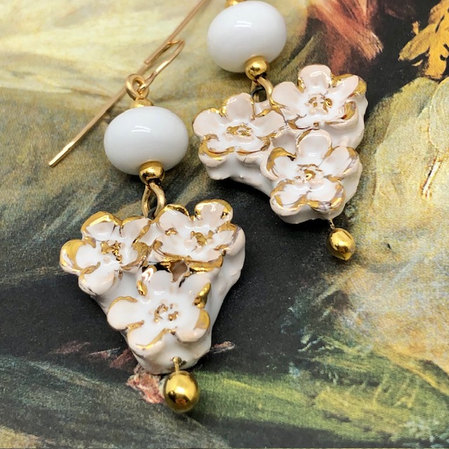 Boucles d’oreilles bohèmes composées de pendentifs en céramique qui représentent un bouquet de fleurs blanches et or. Bijoux uniques et poétiques.