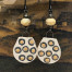 Boucles d'oreilles asymétriques composées de pendentifs en céramique avec un motif abstrait de petites bulles jaunes. Bijoux de créateur.