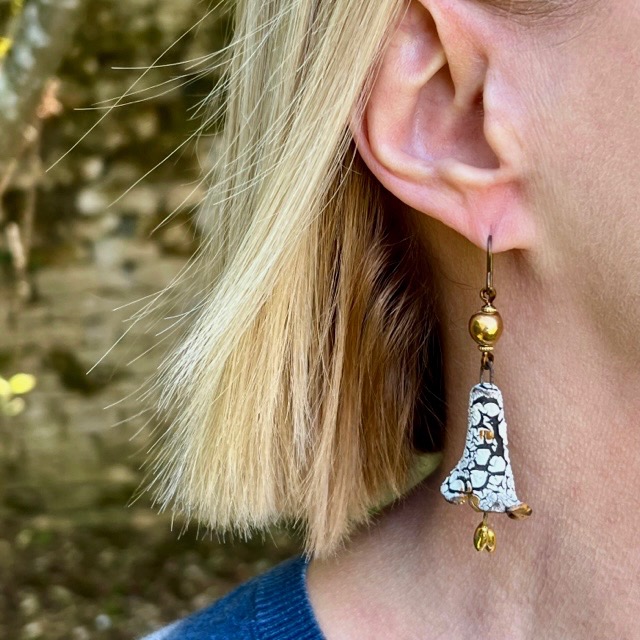 Boucles d'oreilles bohème chic composées de pendentifs en céramique craquelée en forme de campanules, blanches et or. Pièces uniques.