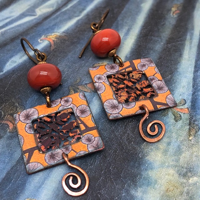 Boucles d'oreilles composées de pendentifs artisanaux en cuivre émaillé et de perles en verre filé à la flamme. Pièces uniques.