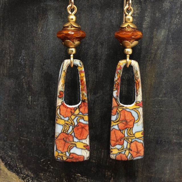 Boucles d'oreilles bohèmes composées de pendentifs en laiton émaillé représentant des capucines orange vif et jaune. Bijoux uniques.