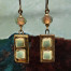 Boucles d’oreilles asymétriques composées de pendentifs artisanaux en céramique avec des carrés en relief vert amande et bronze. Bijoux uniques.
