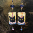 Boucles d'oreilles humoristiques composées de pendentifs en céramique avec le portrait d'un chat déguisé en clown. Bijoux uniques de créateur.