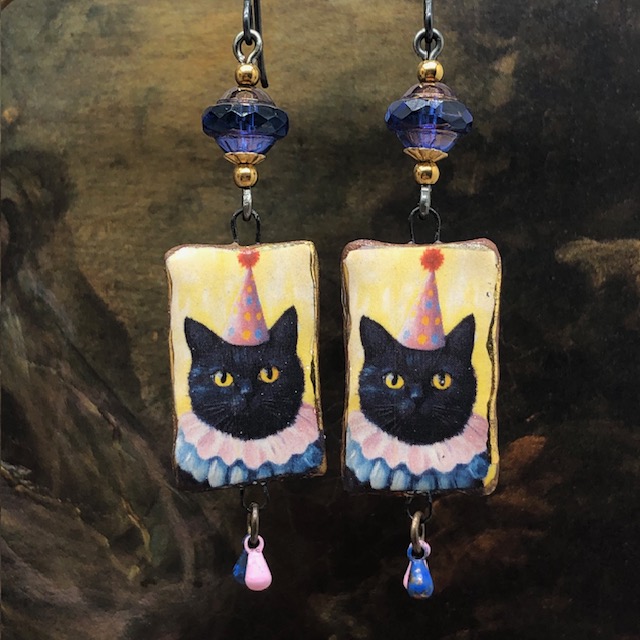 Boucles d'oreilles humoristiques composées de pendentifs en céramique avec le portrait d'un chat déguisé en clown. Bijoux uniques de créateur.
