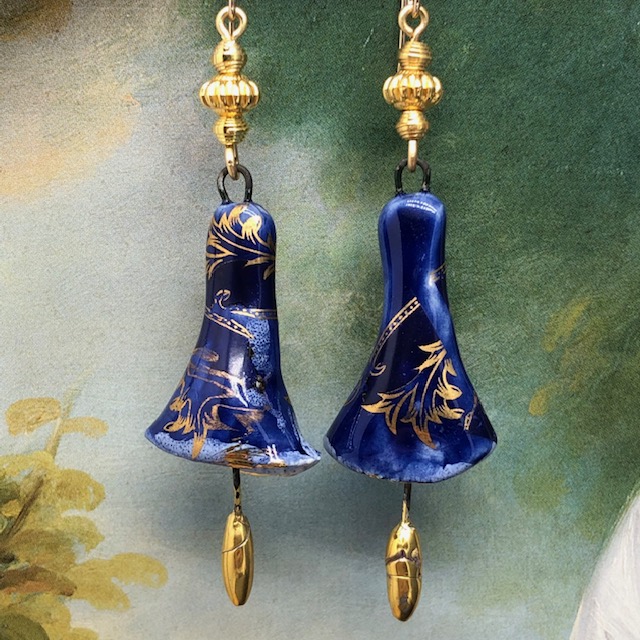 Boucles d'oreilles bohème chic composées de pendentifs en céramique en forme de clochettes bleu nuit et dorées. Modèles uniques.