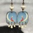 Boucles d’oreilles poétiques composées de pendentifs en cuivre émaillé avec le portrait d'une jeune fille assise sur un croissant de lune. Bijoux uniques.