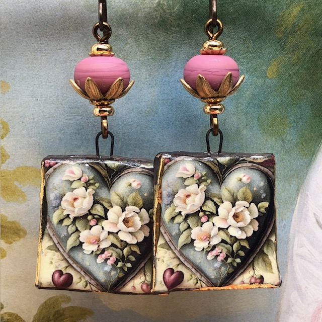 Boucles d'oreilles asymétriques bohèmes composées de pendentifs en cuivre émaillé avec un motif de coeur de fleurs blanches. Bijoux uniques de créateur.