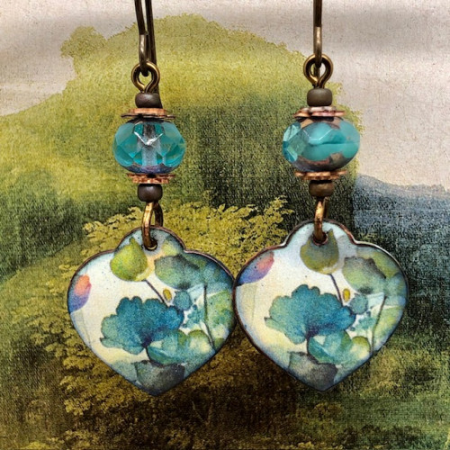 Boucles d'oreilles asymétriques bohèmes composées de pendentifs en cuivre émaillé en forme de coeur, avec un motif de fleurs turquoise. Bijoux uniques.