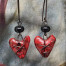 Boucles d'oreilles vintage composées de pendentifs en céramique en forme de coeur cousu rouges et de perles lampwork noires. Bijoux uniques.