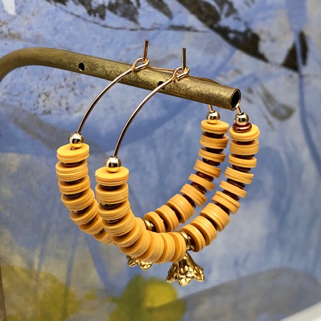 Boucles d'oreilles créoles composées de perles africaines Heishi en vinyles recyclés jaune safran et de petites perles japonaises.