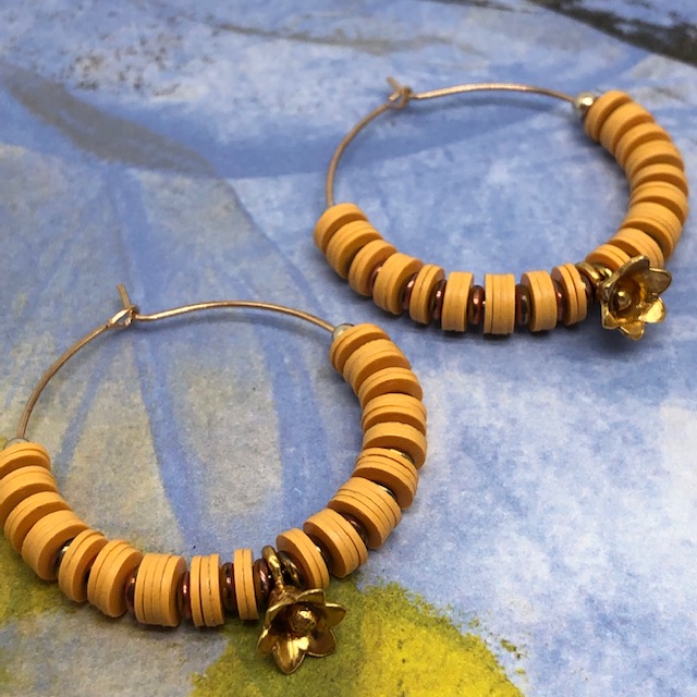 Boucles d'oreilles créoles composées de perles africaines Heishi en vinyles recyclés jaune safran et de petites perles japonaises.