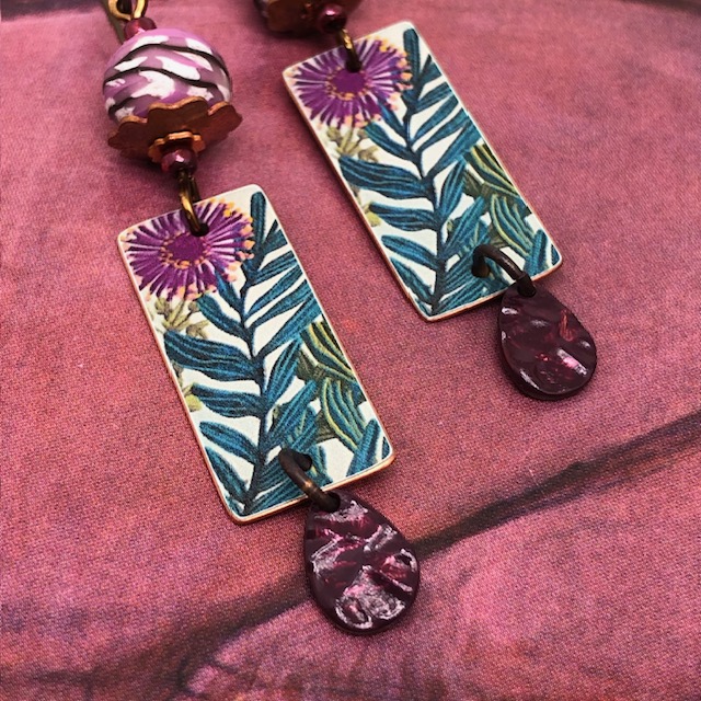 Boucles d'oreilles de créateur bohèmes composées de pendentifs en cuivre illustré avec un motif de dahlias mauves. Bijoux uniques.