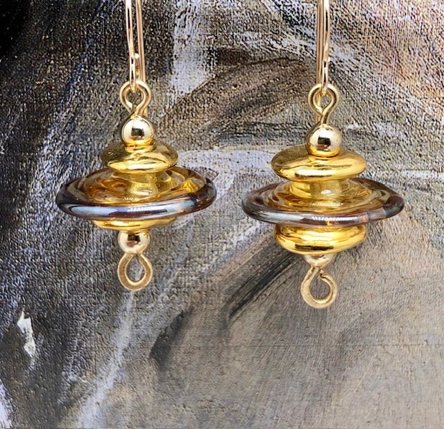 Boucles d'oreilles asymétriques composées de perles disques en verre filé à la flamme et de perles en céramique. Bijoux uniques de créateur.