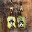 Boucles d’oreilles asymétriques composées de pendentifs en céramique avec des chiens portant un chapeau haut-de-forme. Bijoux uniques de créateur.