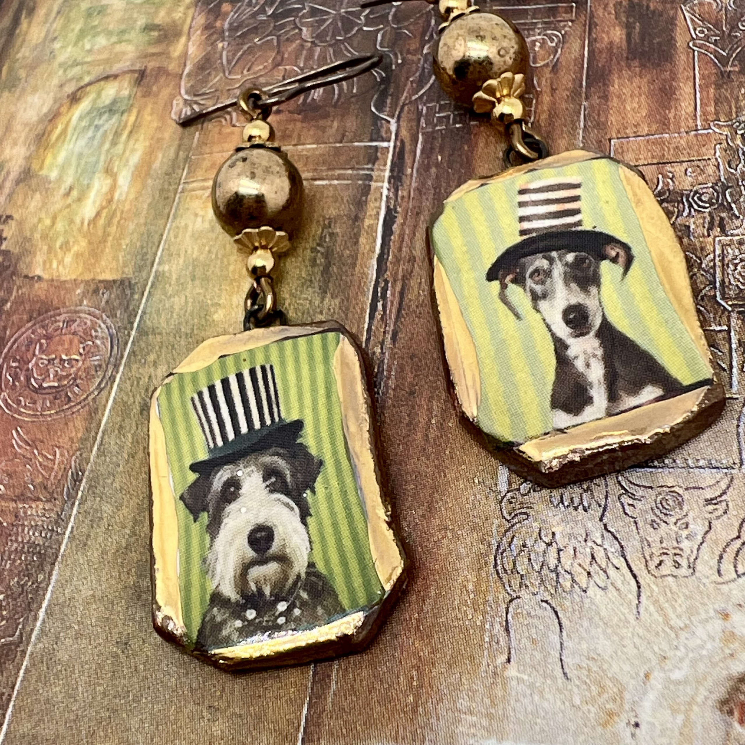 Boucles d’oreilles asymétriques composées de pendentifs en céramique avec des chiens portant un chapeau haut-de-forme. Bijoux uniques de créateur.