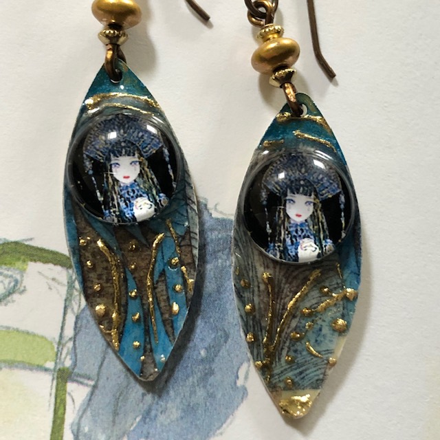 Boucles d'oreilles bohèmes composées de pendentifs en laiton émaillé représentant une poupée sur un fond bleu nuit et or. Bijoux uniques.