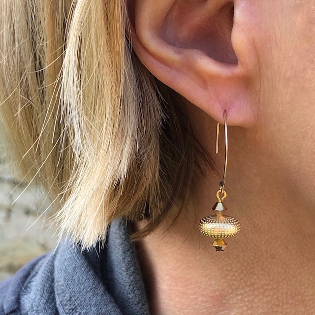 Boucles d'oreilles lumineuses et raffinées composées de perles en laiton martelé or et de perles en cristal Swaroski doré.