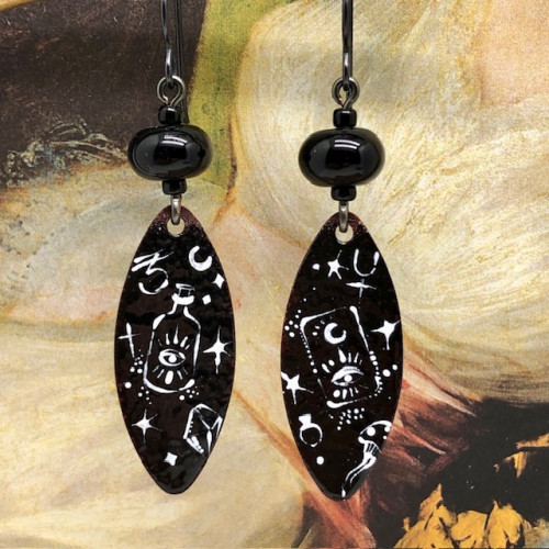 Boucles d'oreilles asymétrique et ésotériques, composées de pendentifs en cuivre émaillé noir et blanc. Bijoux uniques de créateur.