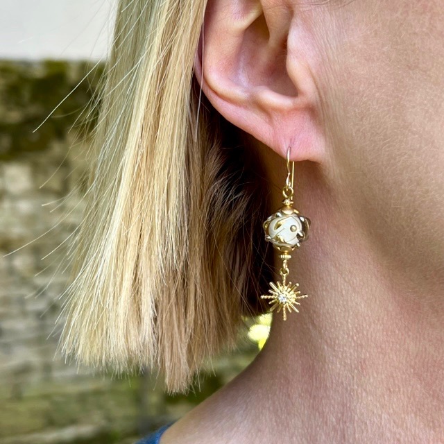 Boucles d'oreilles bohème chic composées de perles en verre filé à la flamme jaune pâle et bronze et de breloques étoiles en strass doré.