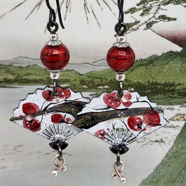 Boucles d’oreilles asymétriques bohème chic composées de pendentifs en cuivre émaillé en forme d'éventail, avec un motif de fleurs rouges. Bijoux uniques.
