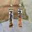 Longues boucles d’oreilles composées de pendentifs en laiton émaillé avec le portrait de femmes africaines porteuses. Bijoux uniques de créateur.