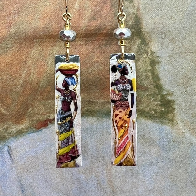 Longues boucles d’oreilles composées de pendentifs en laiton émaillé avec le portrait de femmes africaines porteuses. Bijoux uniques de créateur.