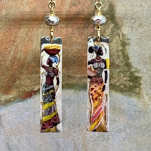 Longues boucles d’oreilles composées de pendentifs en laiton émaillé avec le portrait de femmes africaines porteuses. Bijoux uniques de créateur.