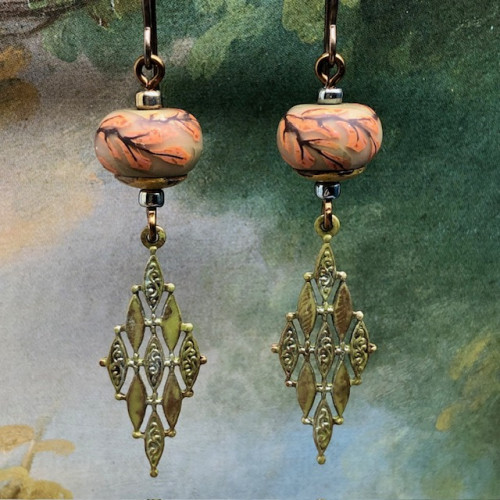 Boucles d’oreilles bohèmes rose corail et kaki composées de perles en argile polymère avec un motif de branche d'arbre. Bijoux uniques de créateur.