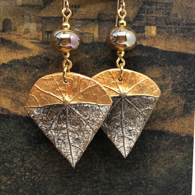 Boucles d'oreilles de fêtes composées de pendentifs avec un motif de feuille d'arbre or et bronze. Bijoux de créateur. Modèle unique.
