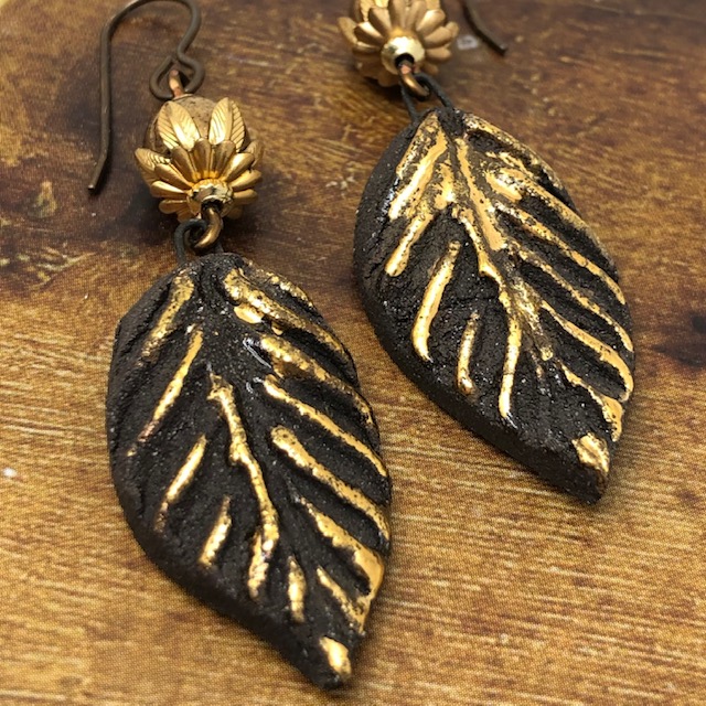 Boucles d'oreilles composées de pendentifs en forme de feuilles noires et or et de perles en verre tchèque. Pièces uniques.