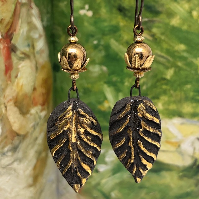 Boucles d'oreilles composées de pendentifs en forme de feuilles noires et or et de perles en verre tchèque. Pièces uniques.