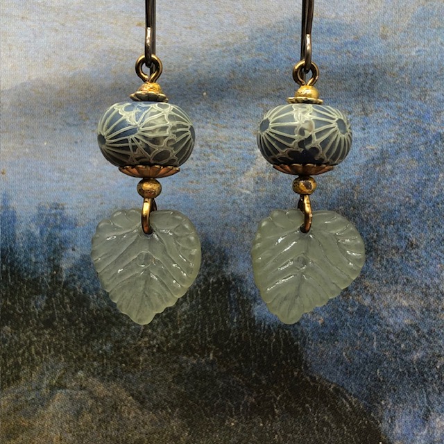 Petites boucles d’oreilles bohèmes composées de feuilles en acrylique kaki et de perles en argile polymère kaki et bleu paon. Bijoux uniques.