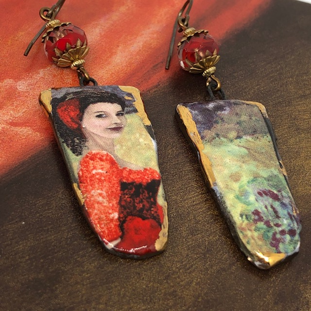 Longues boucles d'oreilles asymétriques composées de pendentifs artisanaux en céramique qui représentent une danseuse de flamenco et un bosquet.