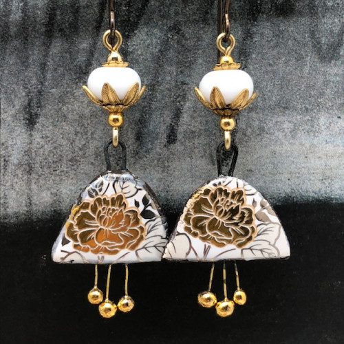 Boucles d'oreilles bohèmes composées de pendentifs en céramique avec un motif de fleurs dorées au feuillage argenté. Bijoux uniques de créateur.