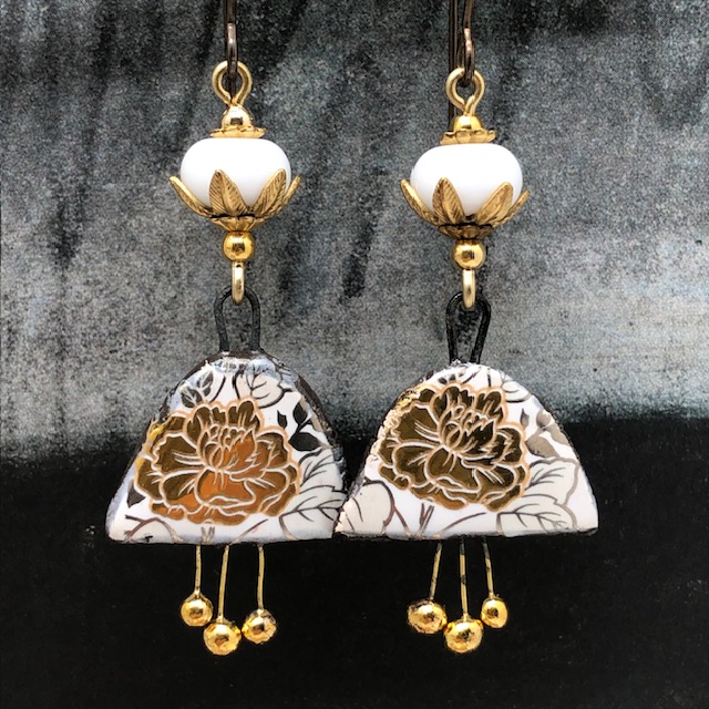 Boucles d'oreilles bohèmes composées de pendentifs en céramique avec un motif de fleurs dorées au feuillage argenté. Bijoux uniques de créateur.